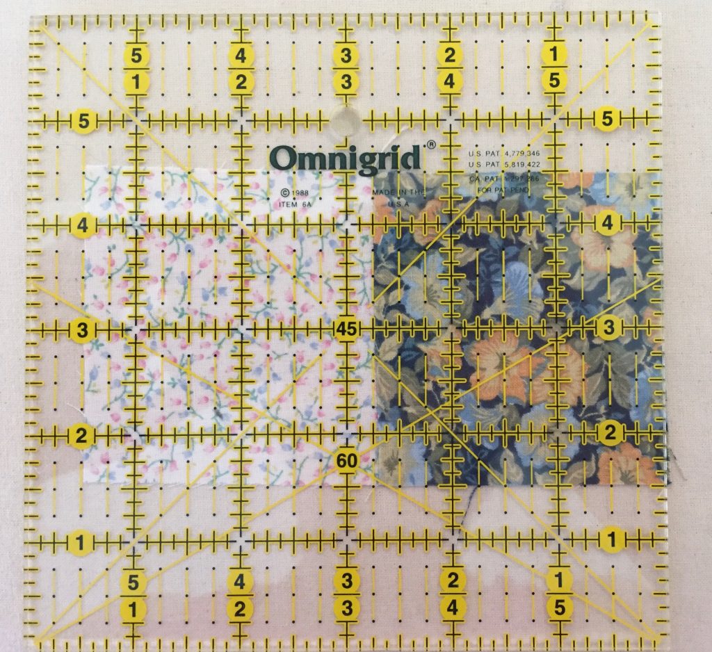 measuring fabric squares with a quilting ruler.