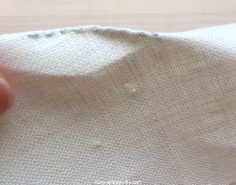 close up of running stitch on a crease in fabric.
