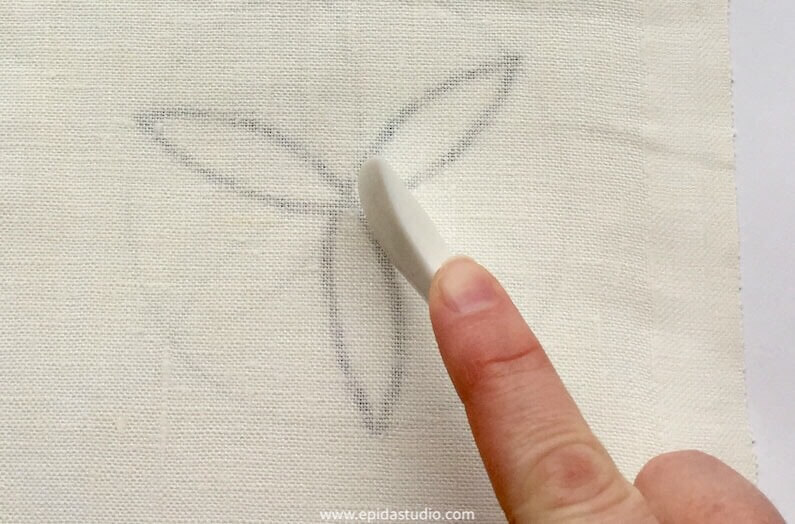 tracing a design onto fabric with a hera marker.