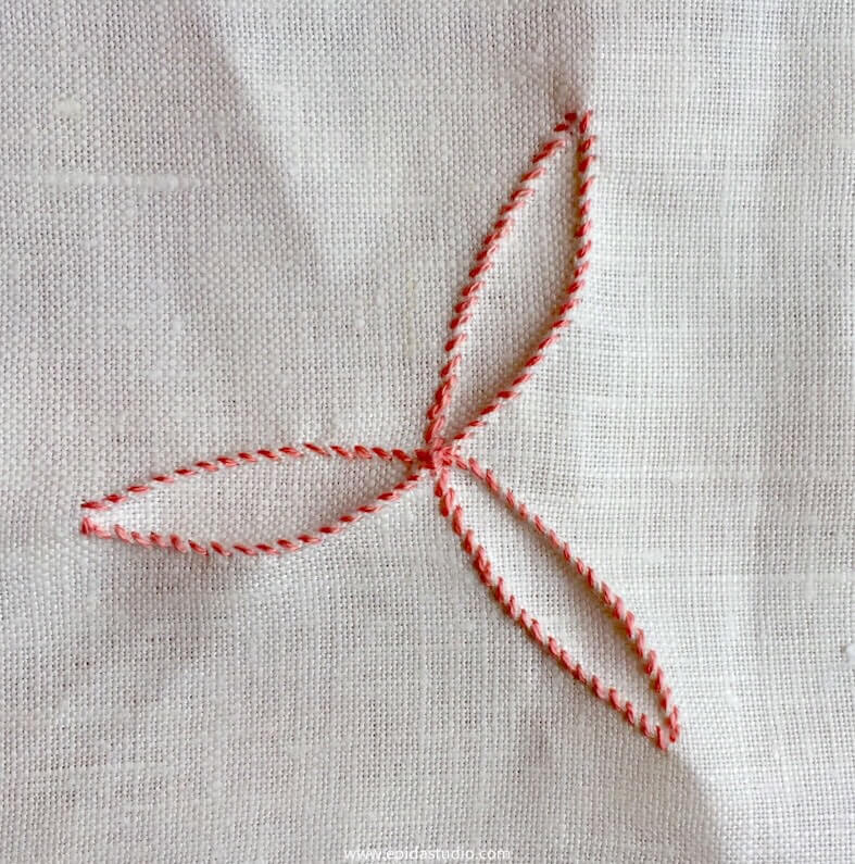 overcast pinch stitch design with pink thread on white fabric.