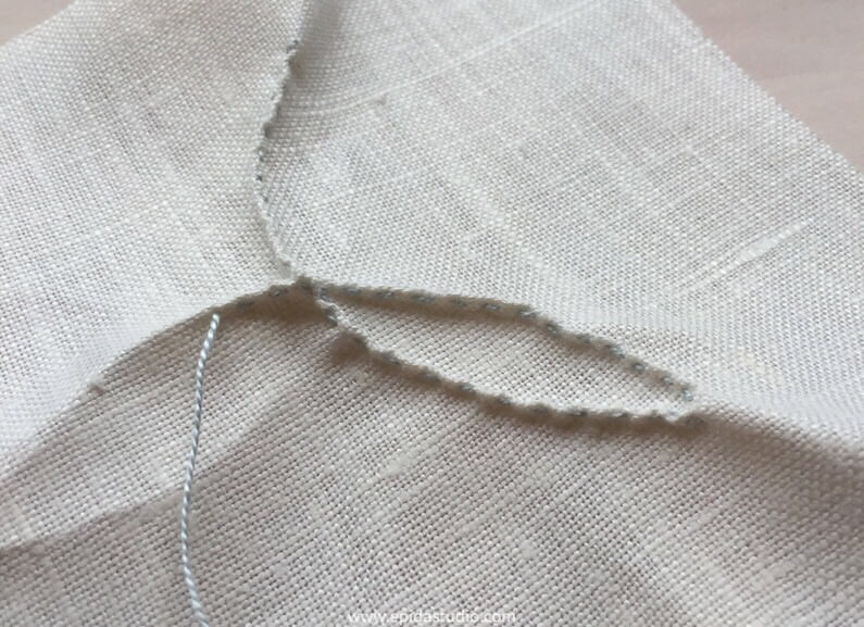 fabric with running pinch stitch in progress.