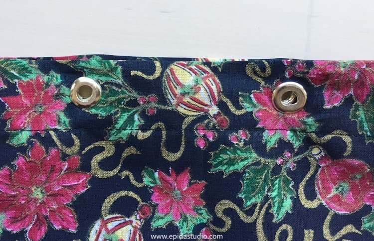 grommets in the top edge of the fabric bag.