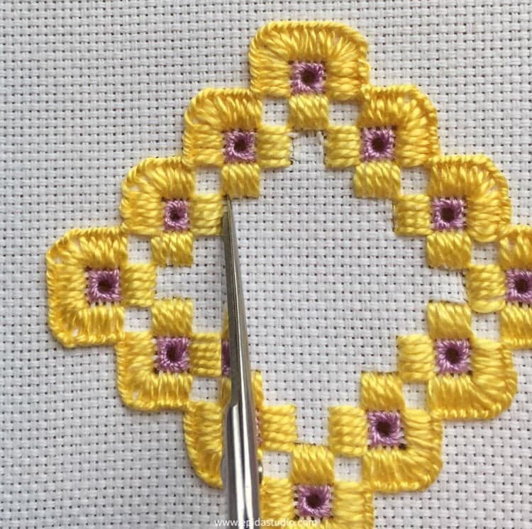 cutting out threads for openwork in hardanger embroidery.