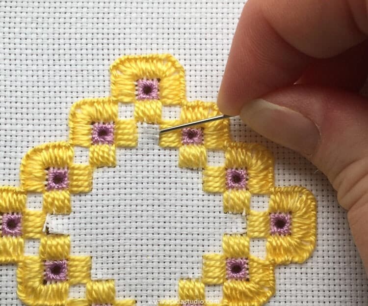 gently removing cut threads with a needle.