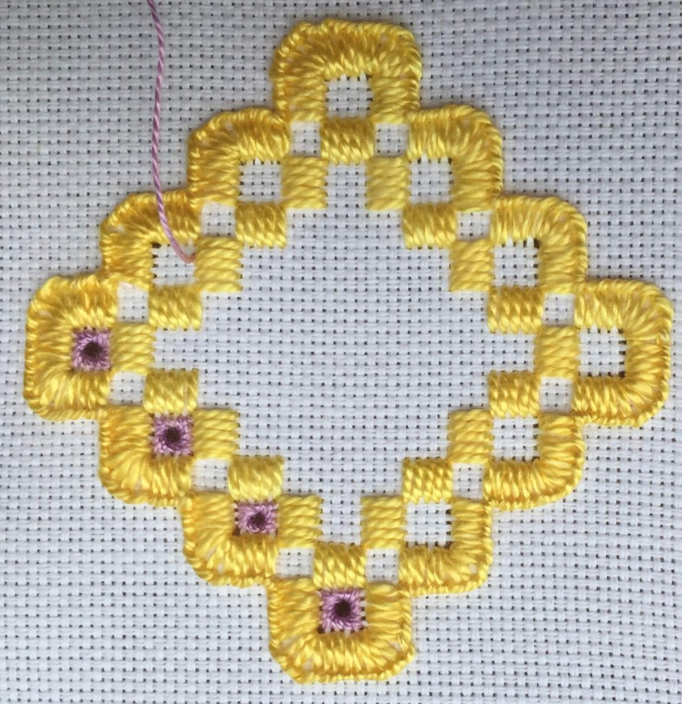 purple eyelets in hardanger embroidery.