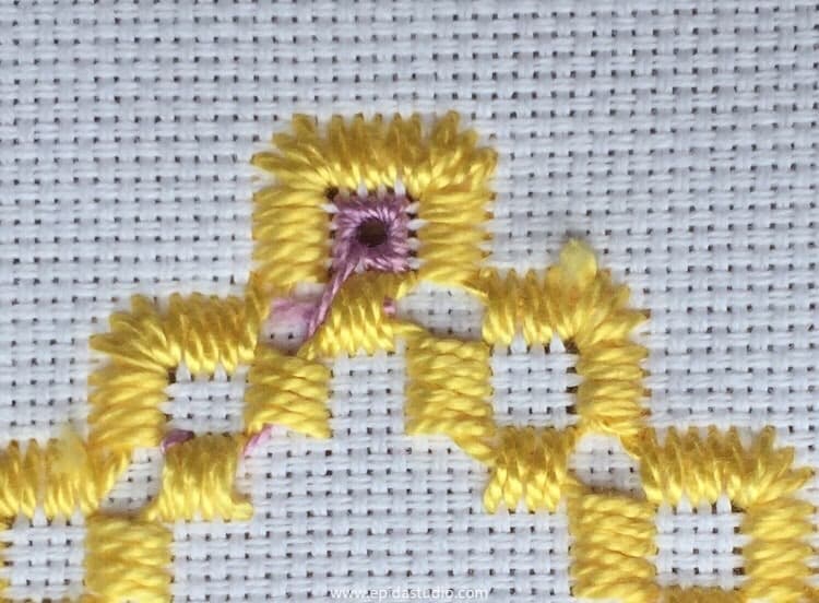 reverse side of hadanger embroidery showing the thread travelling from one eyelet to the next.