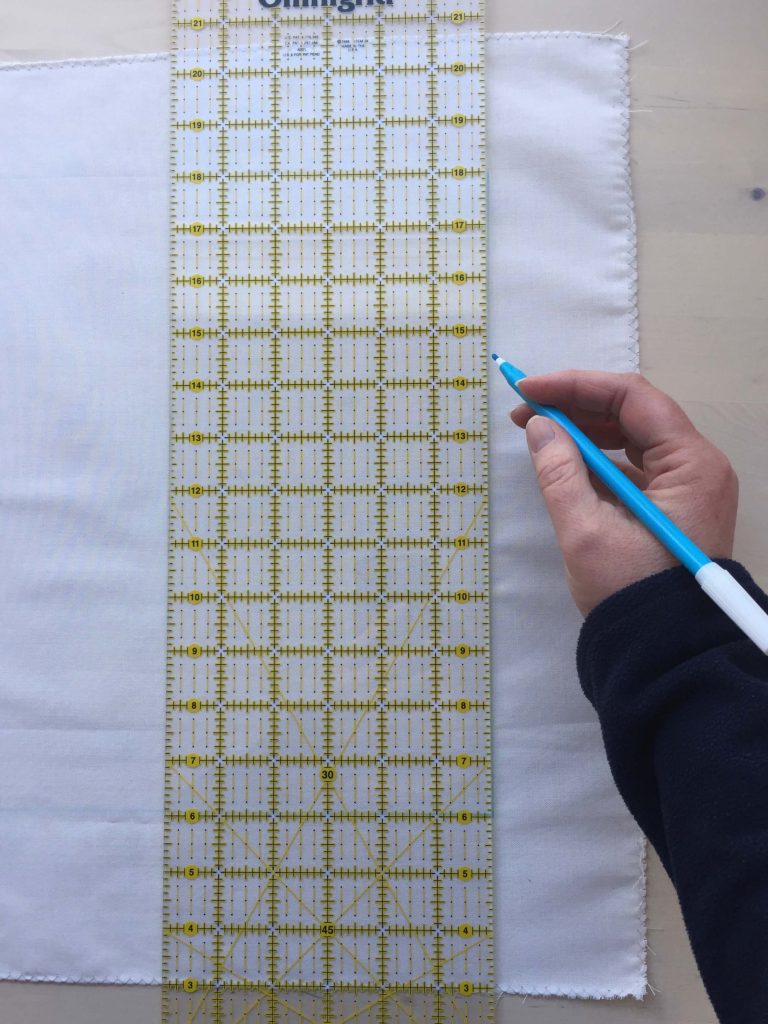 marking a line on fabric with a large ruler and marker