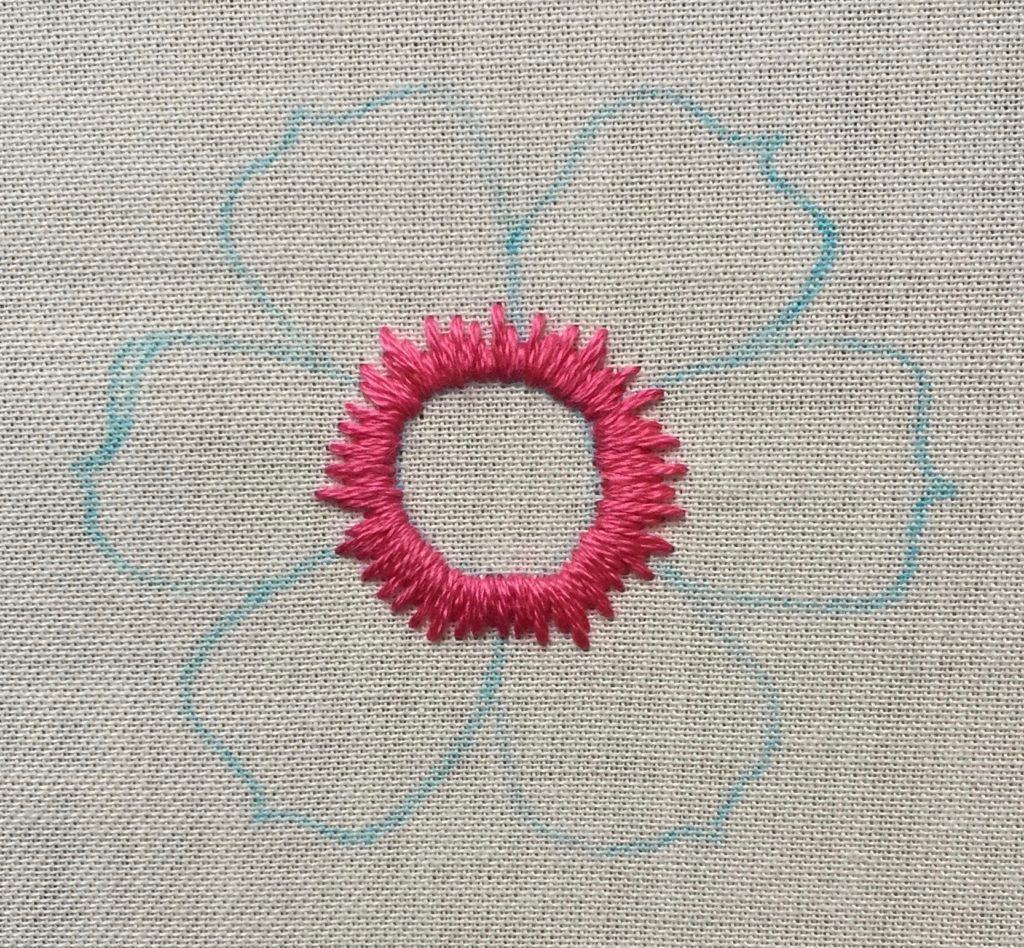 pink embroidery on white fabric