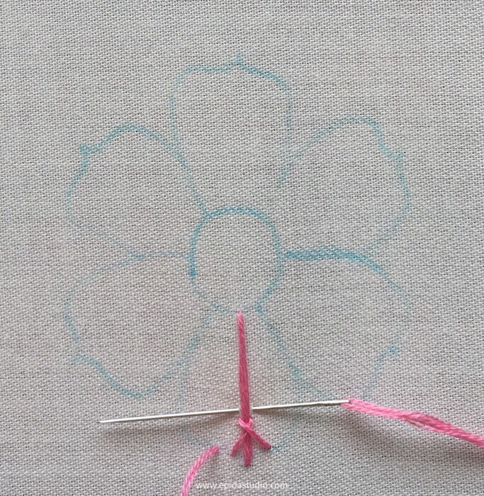 embroidery of a flower with pink floss