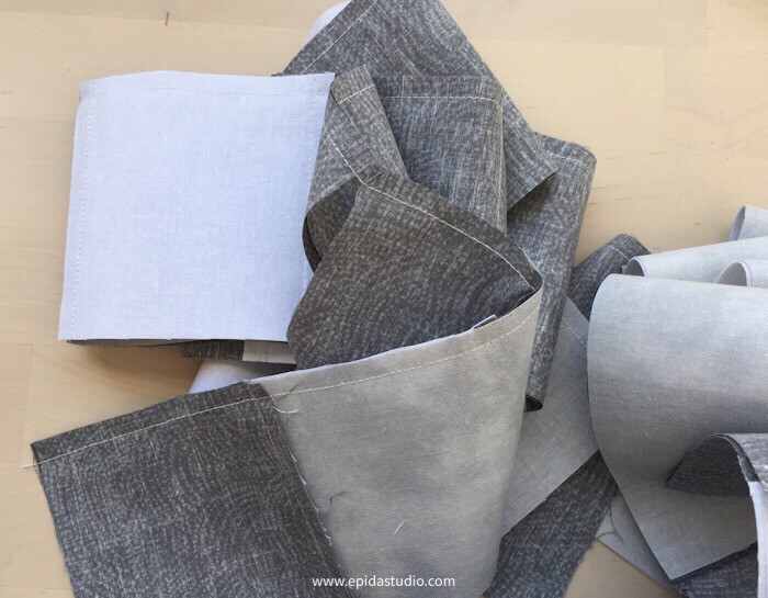 a pile of strips of grey and white fabric
