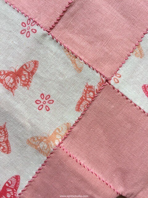 Close up of pojagi stitching with pink and white linen fabrics.