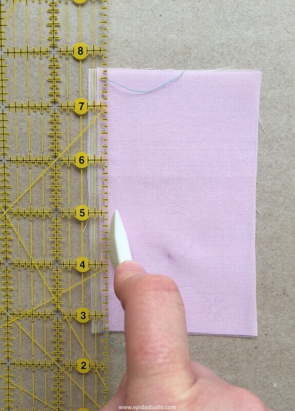 creasing a fabric with a ruler and hera market
