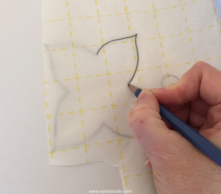 tracing the poinsettia pattern onto paper-backed fusible web.