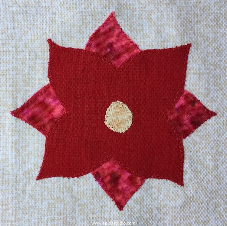 appliqued poinsettia with sewing machine zig zag stitch embellishment.