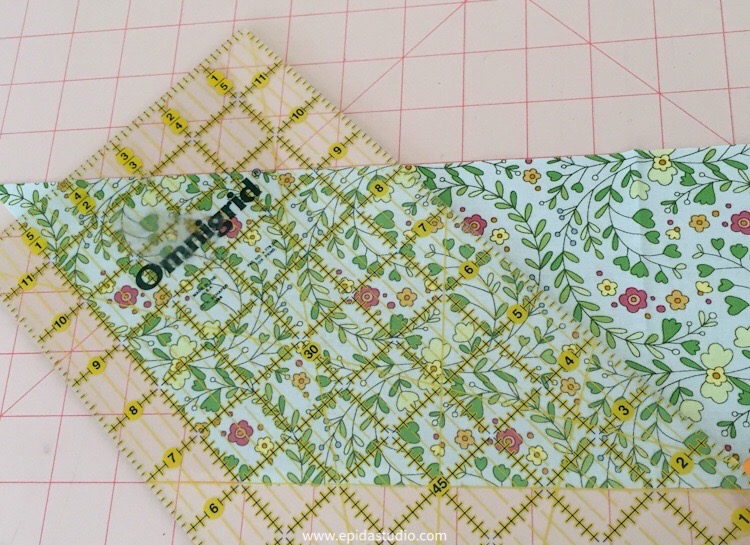 cutting a parallelogram from floral fabric.
