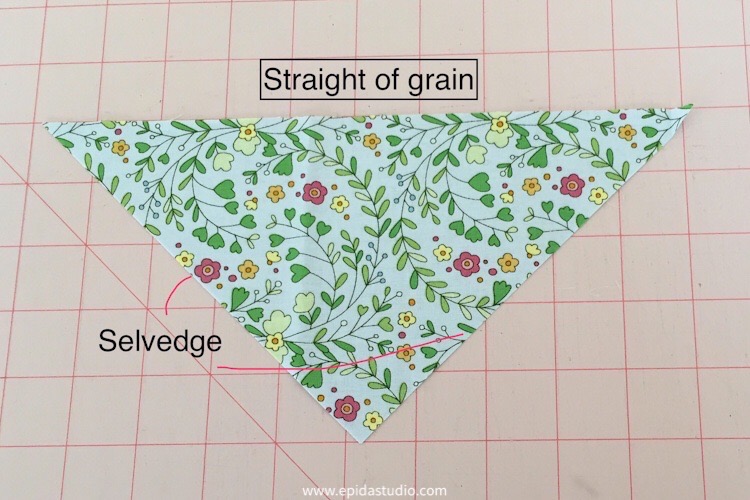 quarter square triangle cut of floral fabric with sides labelled.