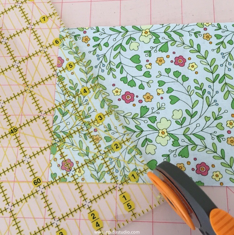 cutting a strip of fabric on a 60* angle.