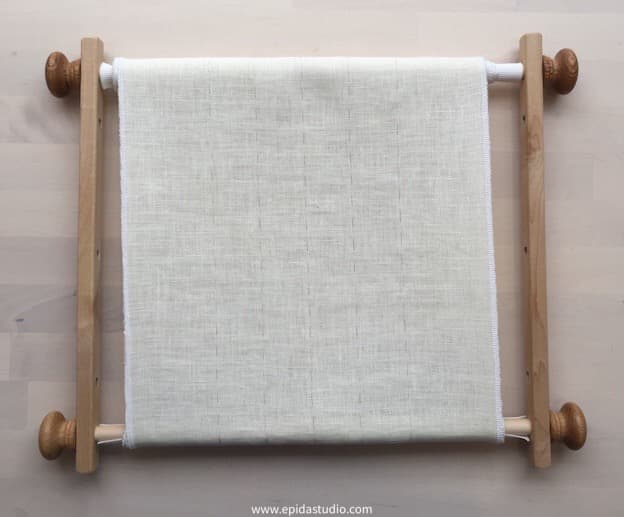 embroidery scroll frame with white fabric.