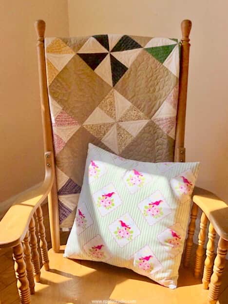 simple pillow on a chair with a quilt.