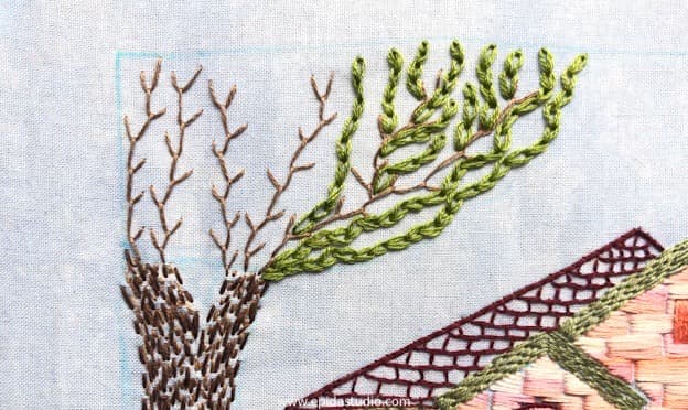 hand embroidering a tree in progress.