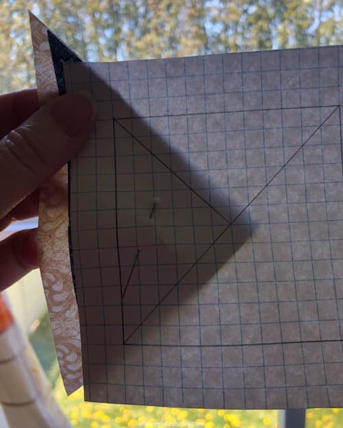 aligning fabric triangles with paper.