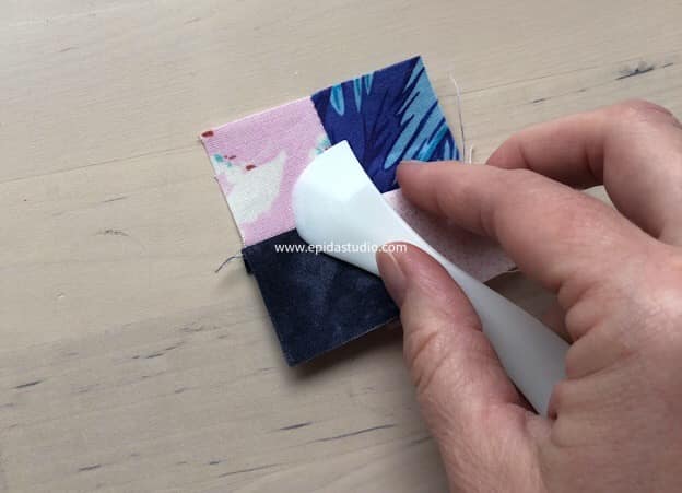 flattening seams on a small four patch with a hera marker