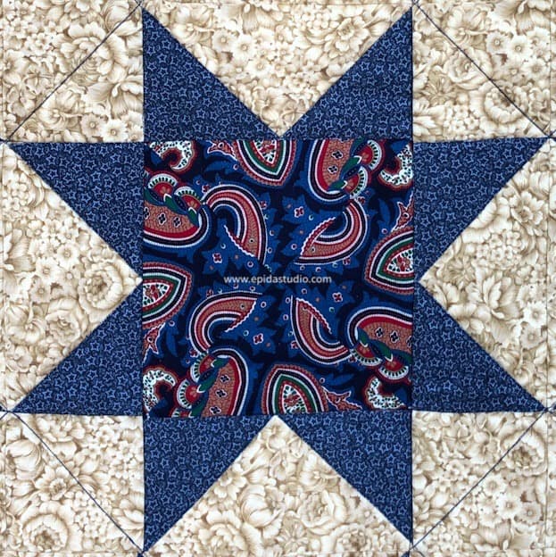 blue and red sawtooth star block on light brown background.