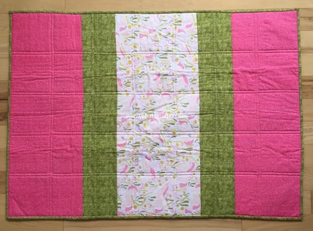 back of quilt with strips of fabric.