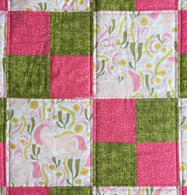 close up of windowpane quilting in squares baby quilt.